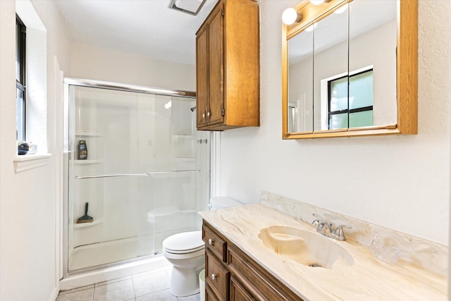 bathroom with toilet, vanity, tile patterned floors, and walk in shower