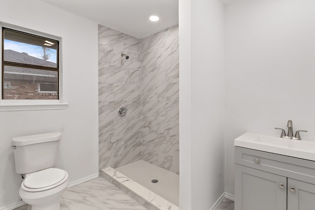 bathroom featuring vanity, toilet, and tiled shower