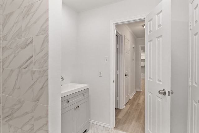 bathroom with vanity, wood-type flooring, and ornamental molding