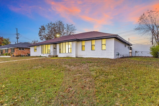 single story home featuring a lawn