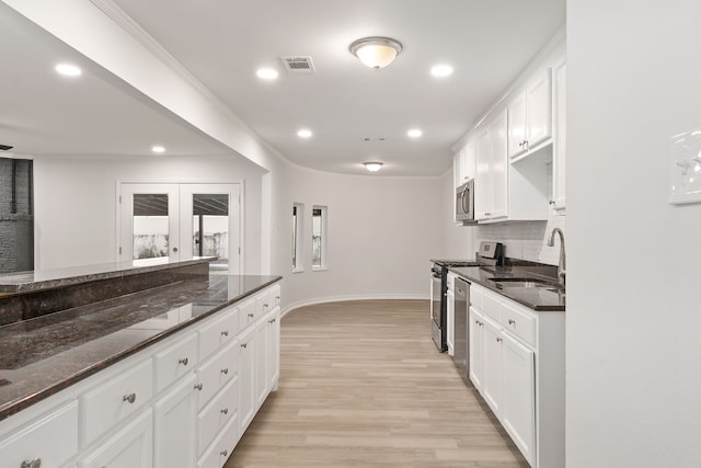 kitchen featuring dark stone countertops, sink, white cabinets, and appliances with stainless steel finishes