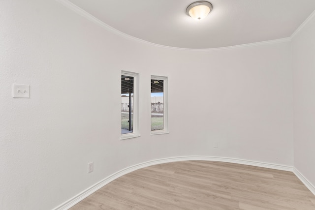 spare room featuring ornamental molding and light hardwood / wood-style flooring