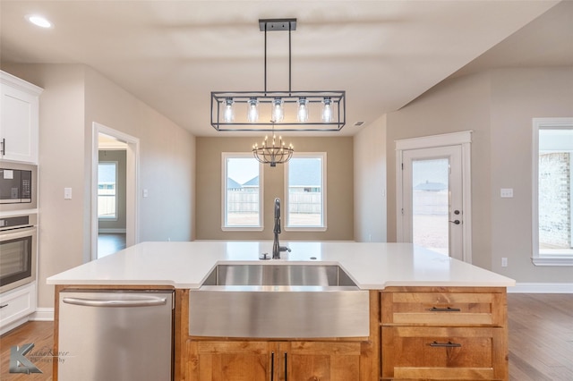 kitchen featuring white cabinetry, sink, a kitchen island with sink, and appliances with stainless steel finishes