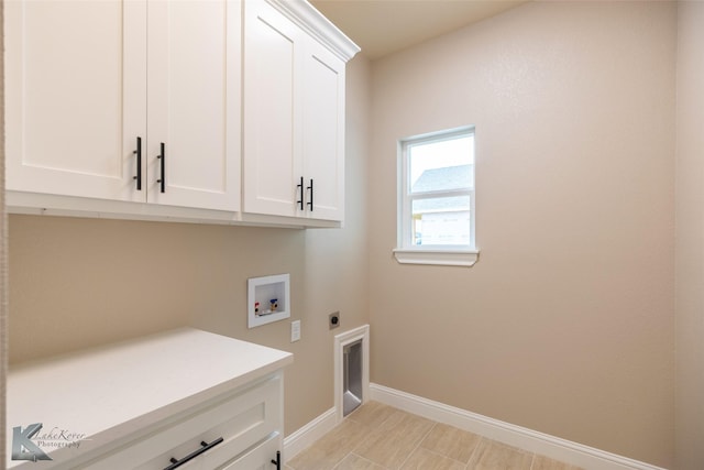 laundry room featuring electric dryer hookup, hookup for a washing machine, and cabinets