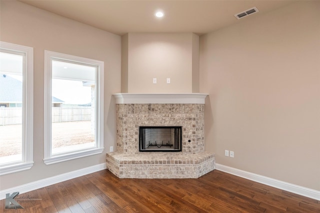 unfurnished living room with dark hardwood / wood-style flooring and a fireplace