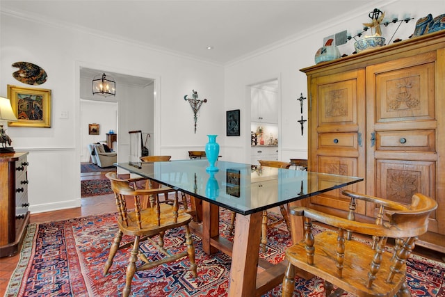 dining room featuring hardwood / wood-style flooring, ornamental molding, and a notable chandelier