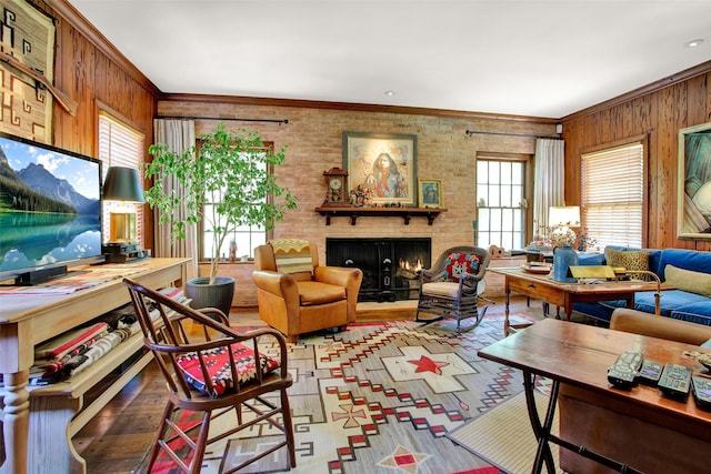 living room with a brick fireplace, a wealth of natural light, wooden walls, and crown molding