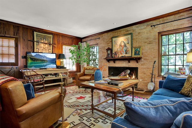 living room with wood walls, crown molding, light wood-type flooring, and a fireplace