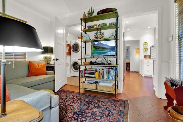 living room featuring stacked washing maching and dryer and crown molding