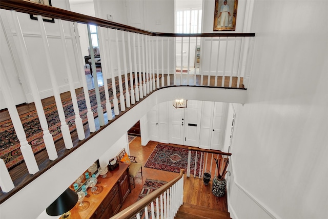 stairs with a wealth of natural light and hardwood / wood-style flooring