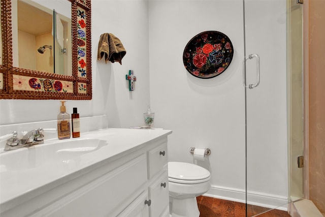 bathroom with hardwood / wood-style flooring, vanity, an enclosed shower, and toilet