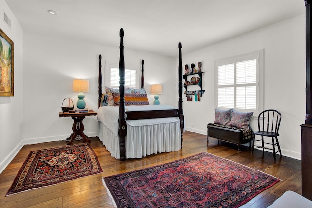 bedroom with multiple windows and dark wood-type flooring