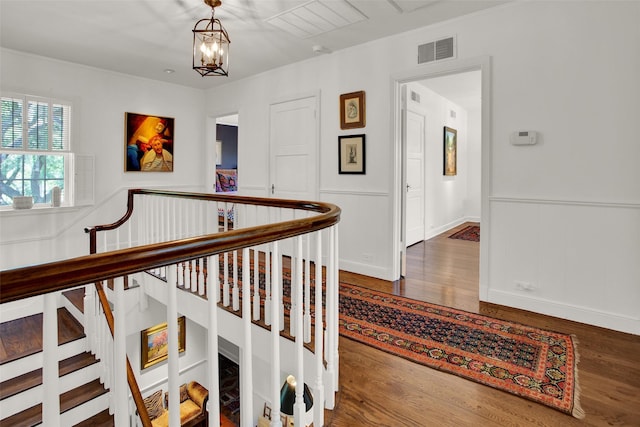 corridor featuring hardwood / wood-style floors and an inviting chandelier