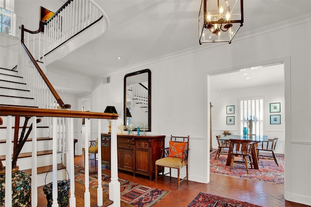 stairway with a notable chandelier and crown molding