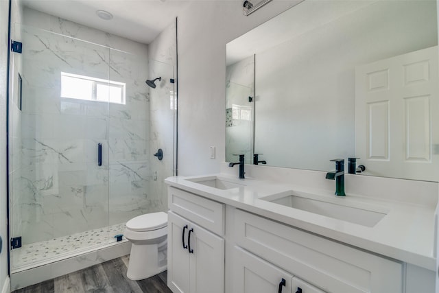 bathroom with hardwood / wood-style floors, vanity, an enclosed shower, and toilet