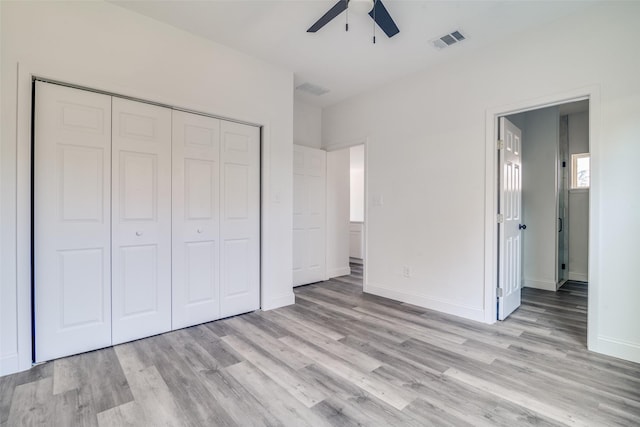 unfurnished bedroom featuring ceiling fan, a closet, and light wood-type flooring