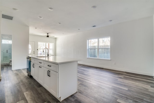 kitchen with white cabinetry, sink, ceiling fan, dark wood-type flooring, and an island with sink