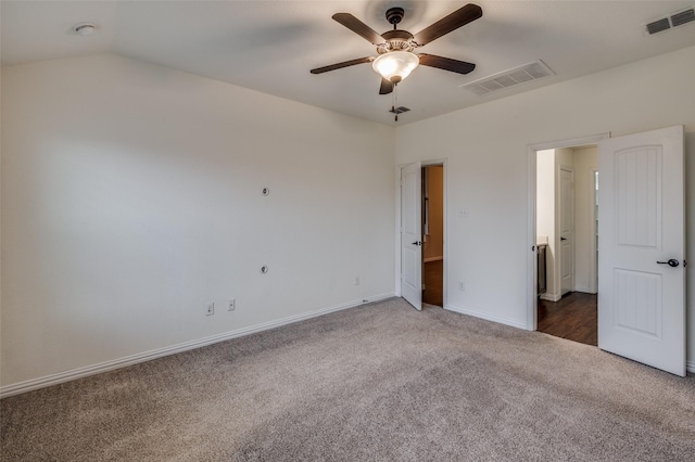 unfurnished bedroom featuring vaulted ceiling, dark carpet, and ceiling fan