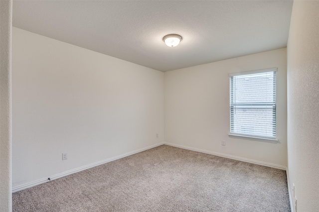 carpeted spare room featuring a textured ceiling