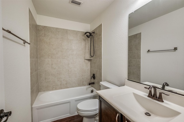 full bathroom with vanity, tiled shower / bath combo, and toilet