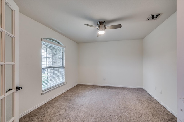 carpeted spare room with ceiling fan