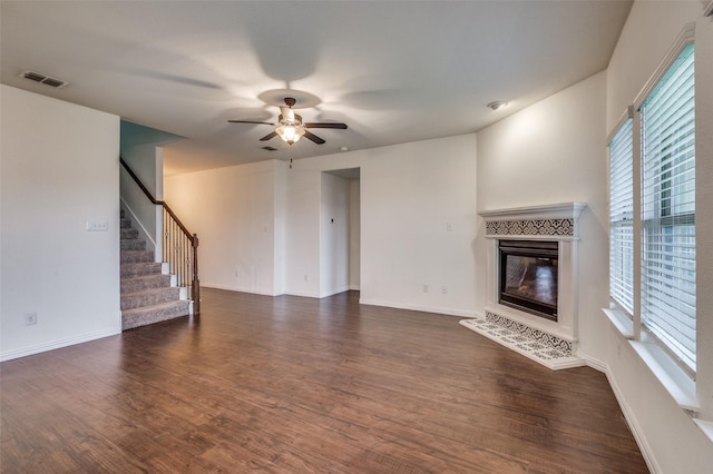 unfurnished living room featuring ceiling fan and dark wood-type flooring