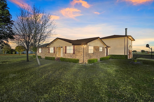 property exterior at dusk with a lawn