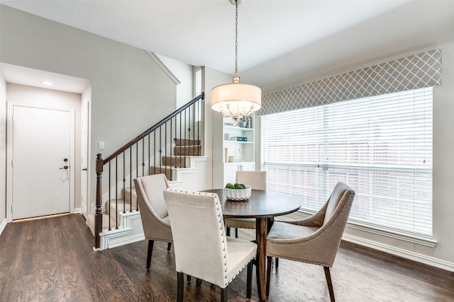 dining space with dark hardwood / wood-style flooring and a notable chandelier