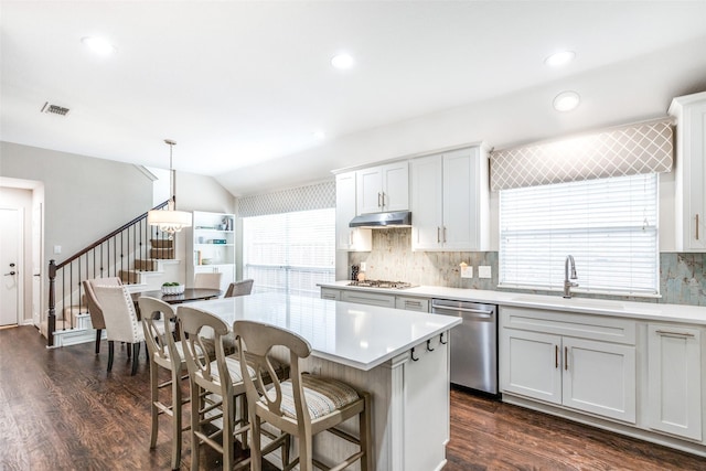 kitchen featuring appliances with stainless steel finishes, dark wood-type flooring, sink, pendant lighting, and white cabinets