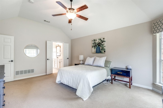 bedroom featuring light colored carpet, ceiling fan, lofted ceiling, and ensuite bathroom