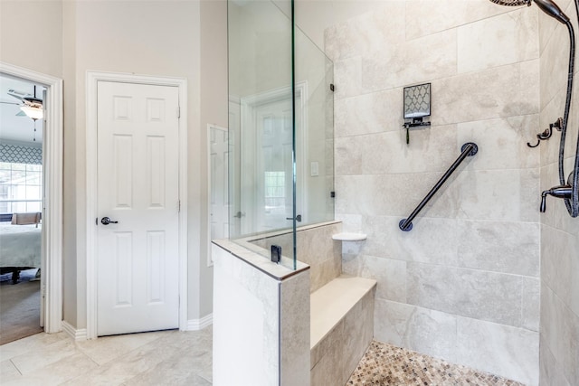 bathroom featuring a tile shower and ceiling fan