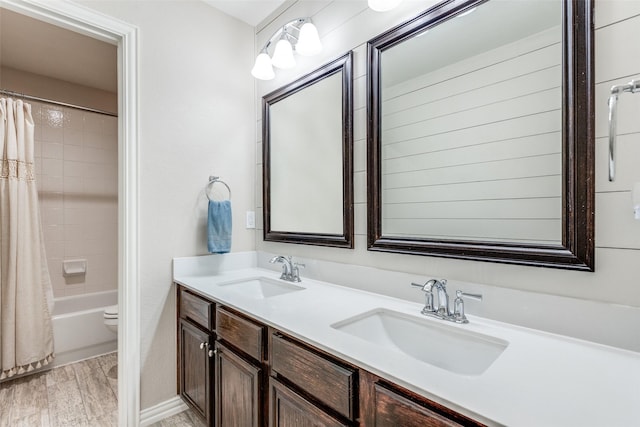 bathroom with wood-type flooring, vanity, and shower / bathtub combination with curtain