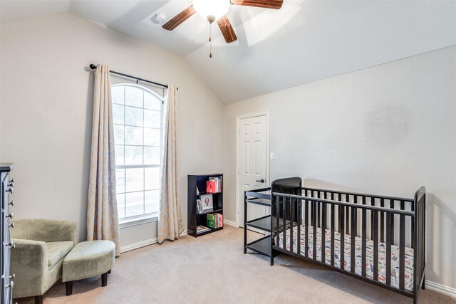 carpeted bedroom with vaulted ceiling, a nursery area, and ceiling fan