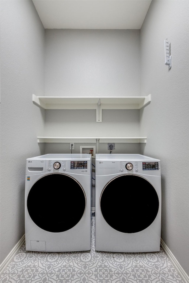 laundry room featuring washing machine and dryer and light tile patterned flooring