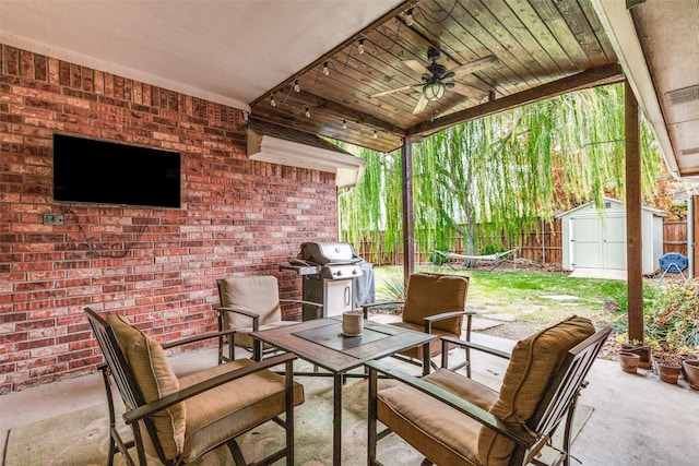 view of patio featuring grilling area, ceiling fan, and a storage unit