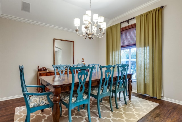 dining room with hardwood / wood-style floors, an inviting chandelier, and crown molding