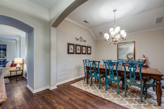 dining area with a notable chandelier, wood-type flooring, ornamental molding, and lofted ceiling