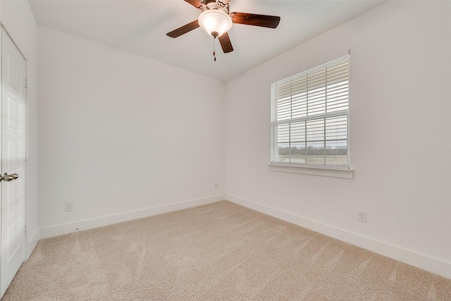 carpeted spare room with ceiling fan