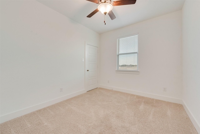 carpeted spare room with ceiling fan