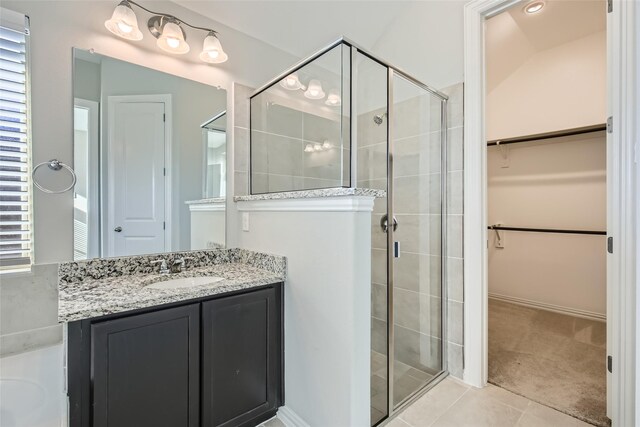 bathroom featuring tile patterned flooring, vanity, a shower with door, and lofted ceiling