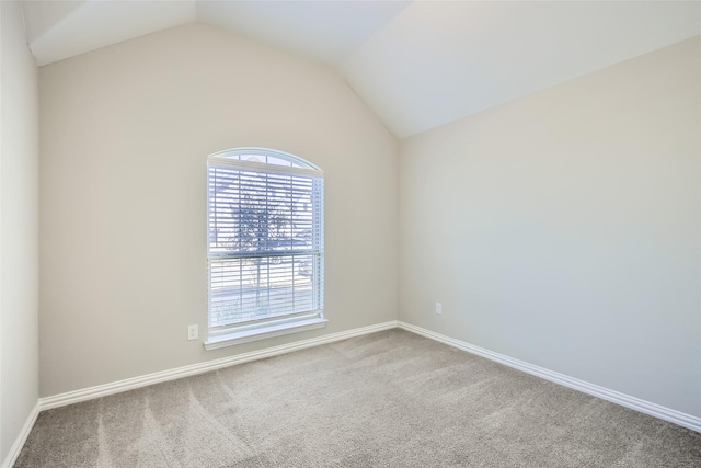 carpeted empty room with lofted ceiling