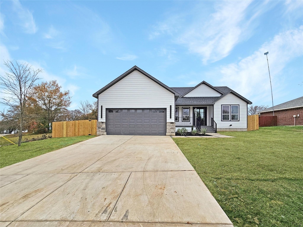 view of front facade featuring a front lawn, covered porch, and a garage