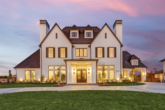 view of front of property featuring a lawn and french doors