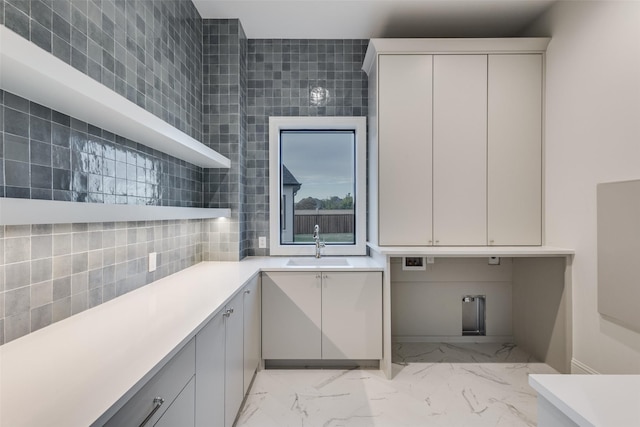 laundry area featuring sink and tile walls