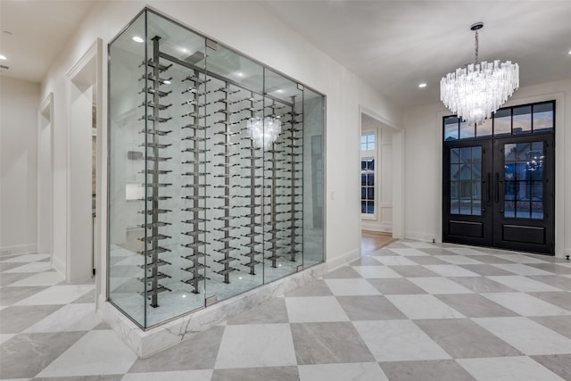 wine cellar with an inviting chandelier and french doors