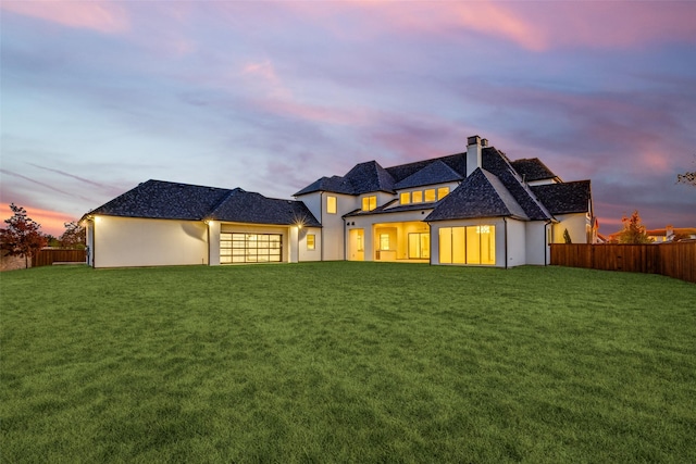 back house at dusk with a yard