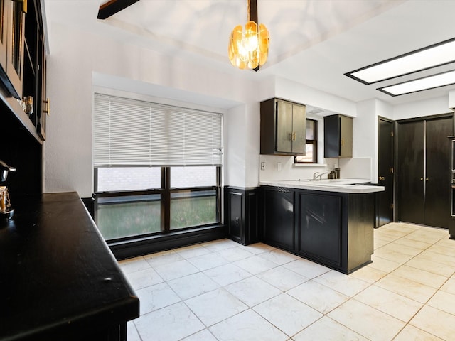 kitchen with kitchen peninsula, light tile patterned floors, pendant lighting, and an inviting chandelier