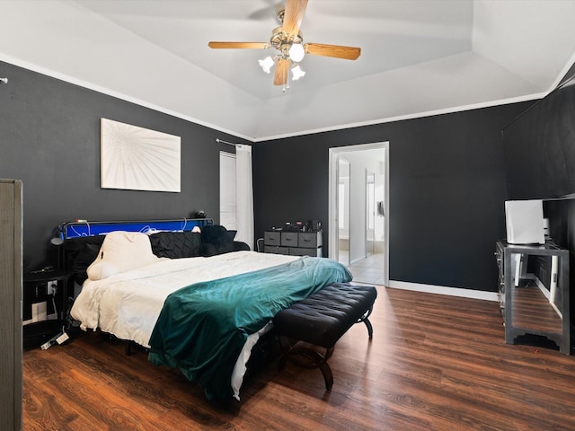 bedroom with ensuite bath, ceiling fan, a raised ceiling, wood-type flooring, and ornamental molding