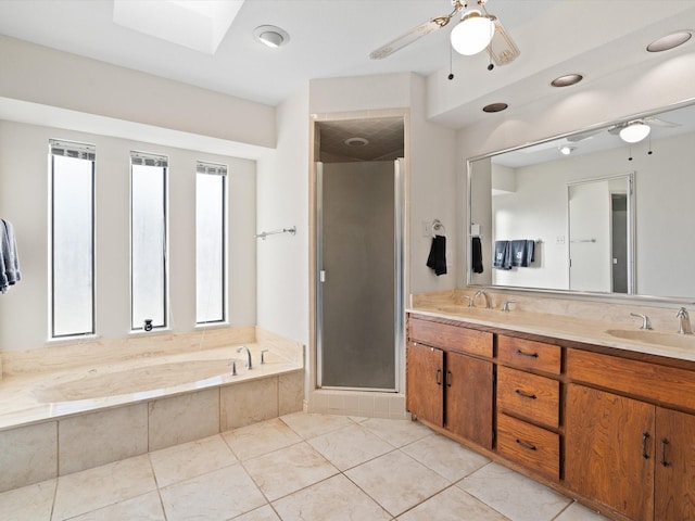 bathroom with vanity, tile patterned floors, a skylight, ceiling fan, and shower with separate bathtub