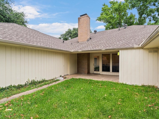 back of property with a yard and a patio